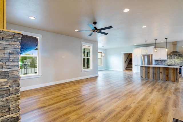 unfurnished living room featuring plenty of natural light, baseboards, a ceiling fan, and recessed lighting