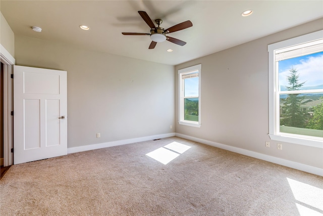 carpeted empty room featuring baseboards, recessed lighting, ceiling fan, and a smoke detector