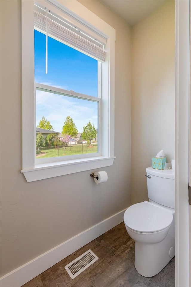 bathroom featuring baseboards, toilet, and wood finished floors