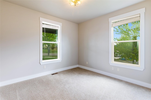 carpeted empty room featuring baseboards