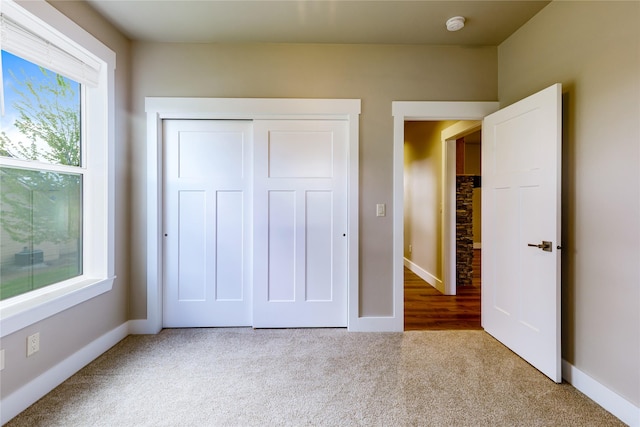 unfurnished bedroom with carpet flooring, baseboards, and a closet