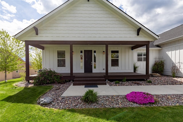 view of front of property with board and batten siding, a porch, and a front lawn
