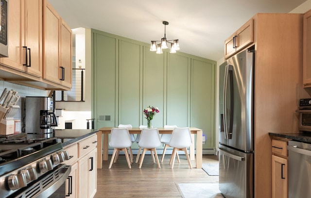 15 Lone Mountain Rd, Clancy, MT 59634 - kitchen featuring appliances with stainless steel finishes, a chandelier, light wood-style flooring, a decorative wall, and a baseboard heating unit