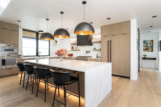 kitchen featuring modern cabinets, open shelves, a sink, and light wood finished floors