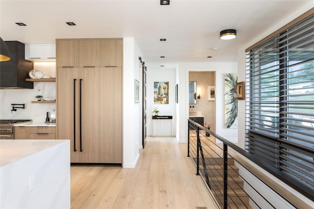 kitchen with modern cabinets, light wood-style flooring, open shelves, light countertops, and premium appliances