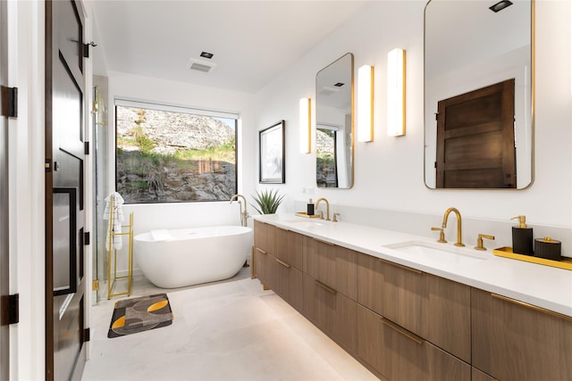 bathroom with a freestanding tub and double vanity