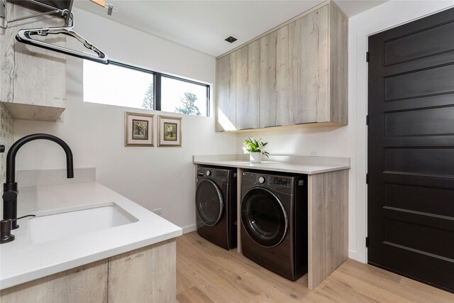48 Eagle Rock Dr, Bigfork, MT 59911 - laundry room featuring independent washer and dryer, cabinet space, and light wood finished floors