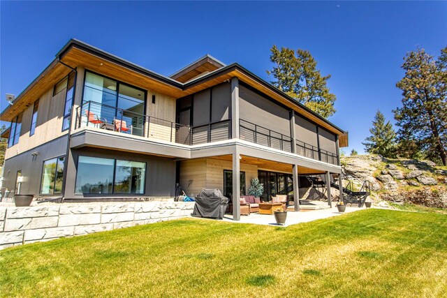 48 Eagle Rock Dr, Bigfork, MT 59911 - back of house with a balcony, an outdoor living space, a patio, and a lawn