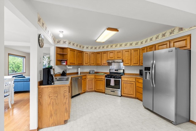 525 Tower St, Missoula, MT 59804 - kitchen with stainless steel appliances, under cabinet range hood, brown cabinets, open shelves, and light floors
