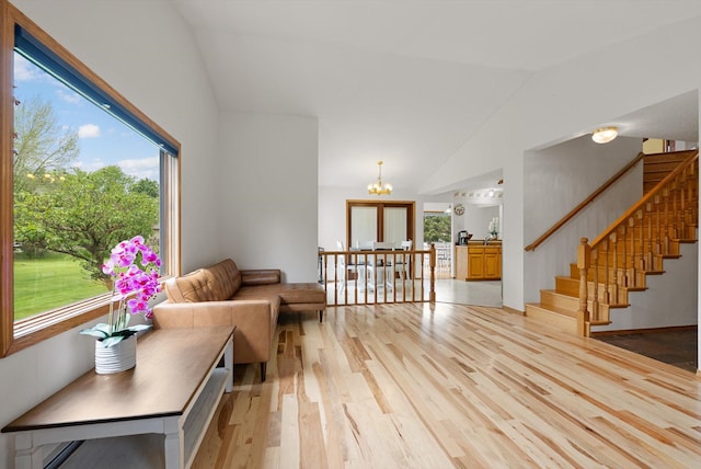 525 Tower St, Missoula, MT 59804 - living room featuring light wood-type flooring, a chandelier, stairs, plenty of natural light, and high vaulted ceiling