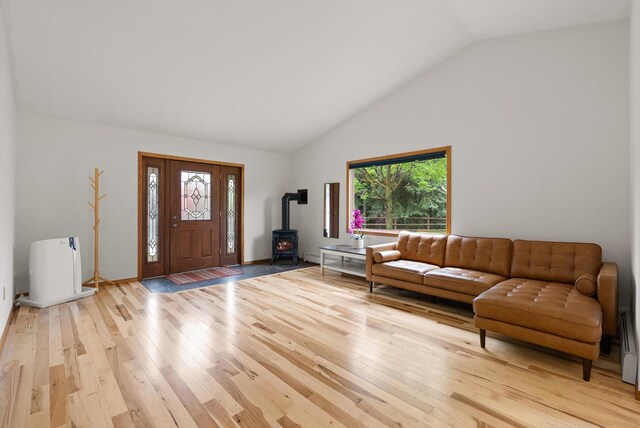 525 Tower St, Missoula, MT 59804 - living room with a wood stove, light wood finished floors, and high vaulted ceiling