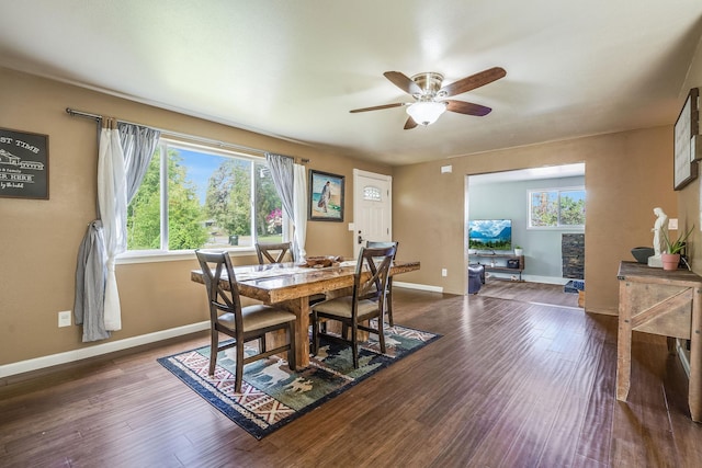 dining room featuring ceiling fan, baseboards, and dark wood-style flooring