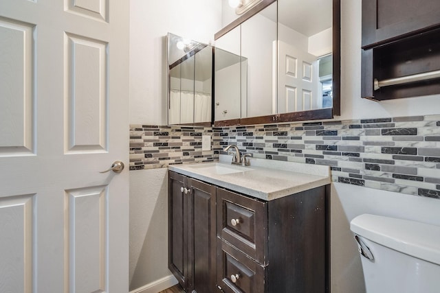 bathroom featuring toilet, backsplash, and vanity