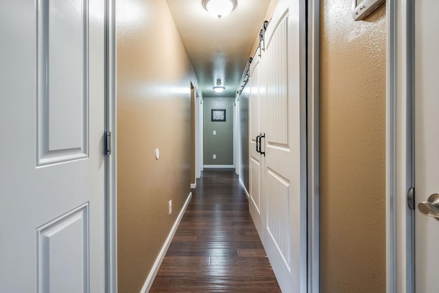 hall with dark wood finished floors and baseboards