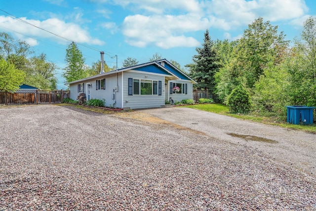 view of front of property with fence and asphalt driveway