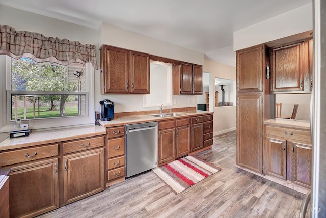 71 Seibold Ln, Cascade, MT 59421 - kitchen featuring dishwasher, a sink, light countertops, light wood-type flooring, and brown cabinetry