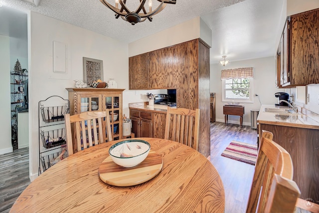 71 Seibold Ln, Cascade, MT 59421 - dining room featuring wood finished floors, baseboards, a chandelier, and a textured ceiling