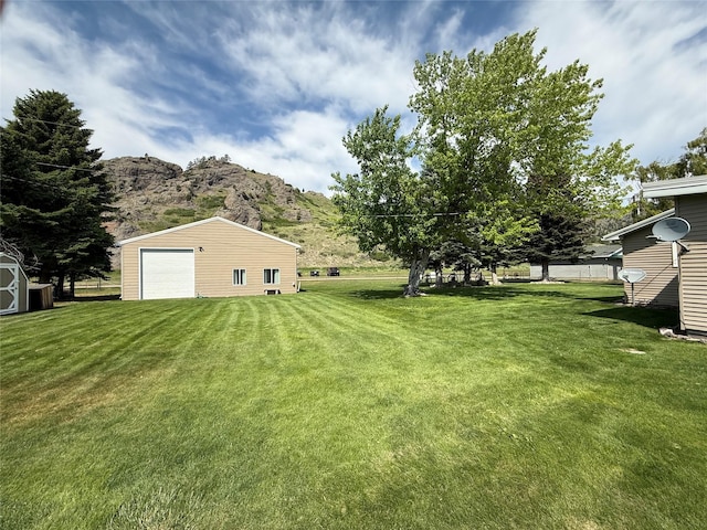 71 Seibold Ln, Cascade, MT 59421 - view of grassy yard featuring a mountain view, an outbuilding, and a detached garage