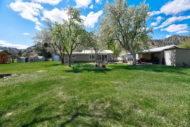 71 Seibold Ln, Cascade, MT 59421 - view of green lawn with a mountain view and a patio area