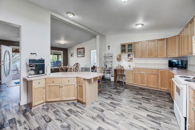 73 Seibold Ln, Cascade, MT 59421 - kitchen with white appliances, lofted ceiling, light brown cabinetry, a peninsula, and light countertops
