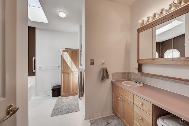 73 Seibold Ln, Cascade, MT 59421 - bathroom featuring vanity, a tub to relax in, baseboards, and a skylight