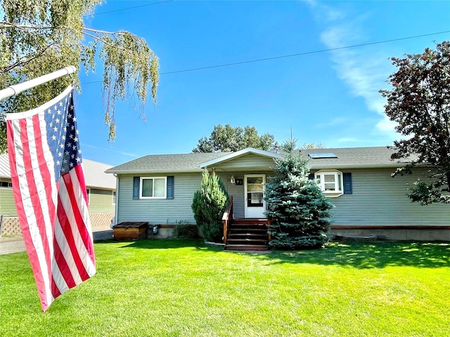 view of front of house with solar panels, a front yard, and a shingled roof