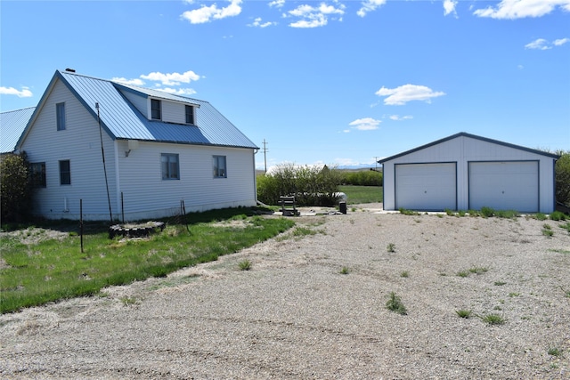 946 Lederer Rd, Conrad, MT 59425 - view of side of home featuring a detached garage, metal roof, and an outdoor structure