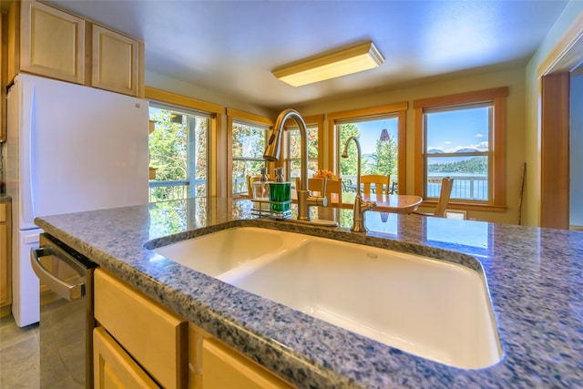 28152 White Swan Ln, Polson, MT 59860 - kitchen with a sink, plenty of natural light, dark stone countertops, and freestanding refrigerator