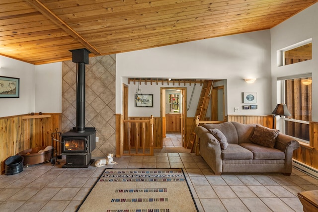 28152 White Swan Ln, Polson, MT 59860 - living area with wooden ceiling, wainscoting, a wood stove, tile patterned floors, and wooden walls