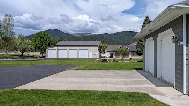 286 Edgewater Dr, Libby, MT 59923 - view of grassy yard with a mountain view, a garage, and asphalt driveway
