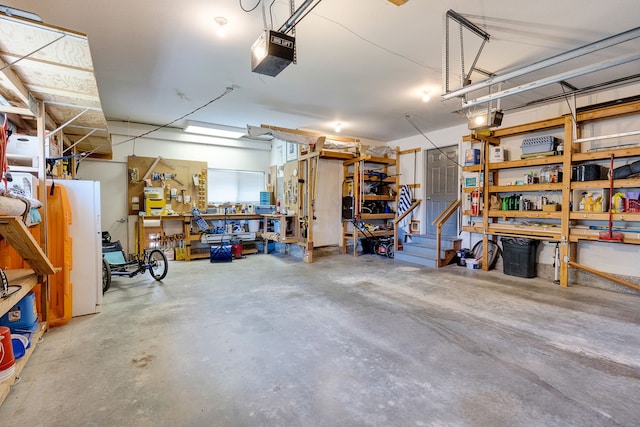 garage with a garage door opener, a workshop area, and freestanding refrigerator