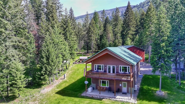 26 Castele Ln, Trout Creek, MT 59874 - back of house with a patio area, a lawn, a deck, and a wooded view
