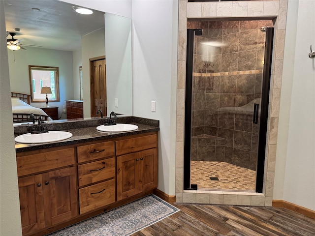 26 Castele Ln, Trout Creek, MT 59874 - ensuite bathroom featuring wood finished floors, a shower stall, ceiling fan, double vanity, and baseboards