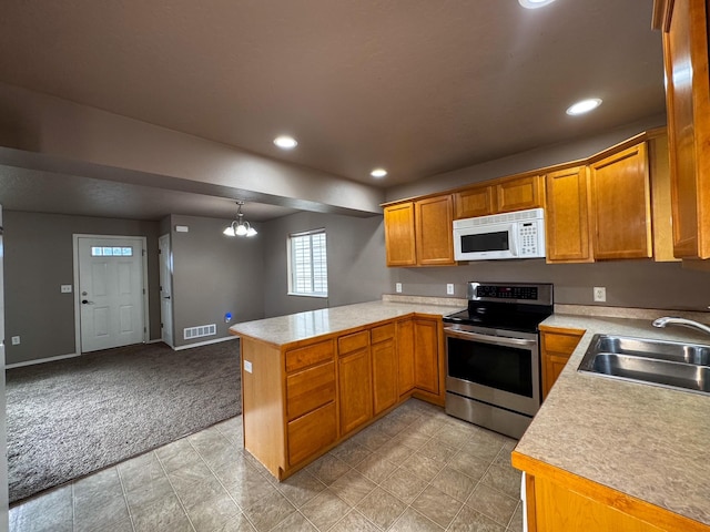 kitchen with white microwave, stainless steel electric range oven, a sink, a peninsula, and recessed lighting