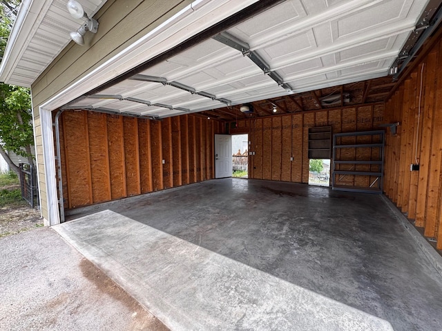 garage with a garage door opener and wood walls