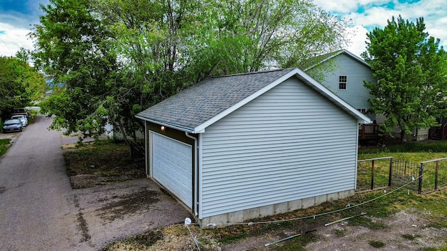 detached garage featuring fence