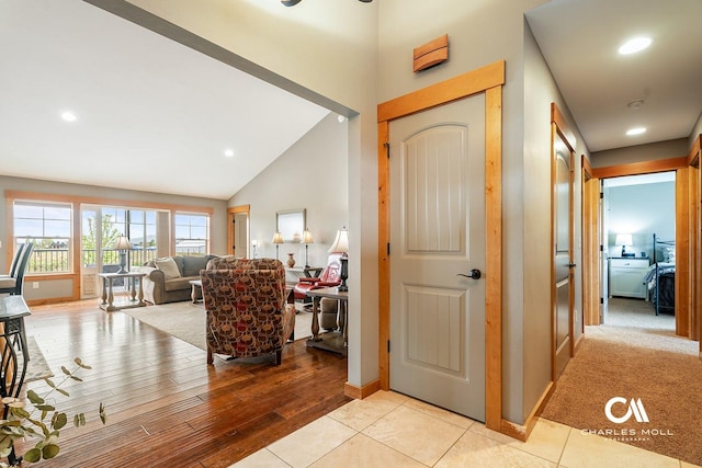 entrance foyer with high vaulted ceiling, baseboards, wood finished floors, and recessed lighting