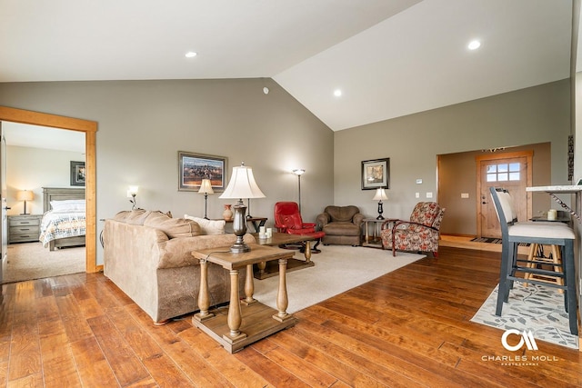 living room featuring light wood-style flooring, high vaulted ceiling, and recessed lighting