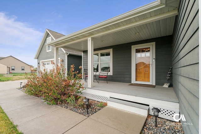 view of exterior entry featuring a porch and a garage