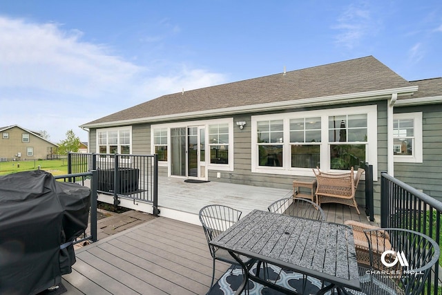wooden terrace with outdoor dining area and area for grilling