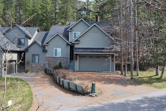 260 Eagle Bend Dr, Bigfork, MT 59911 - view of front of house with stone siding, driveway, a shingled roof, and an attached garage