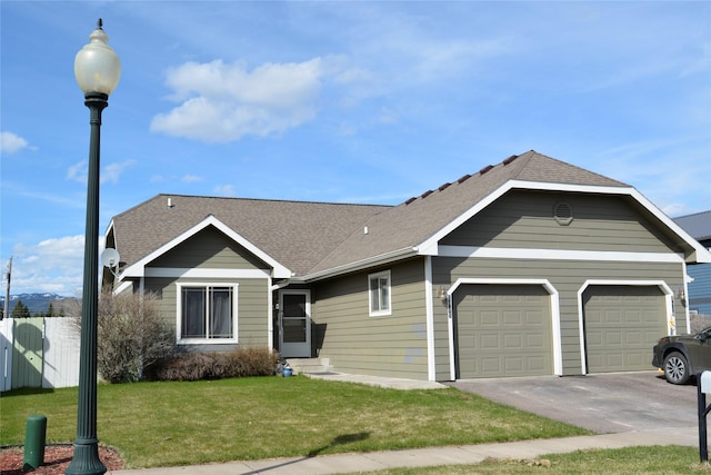 view of front facade featuring an attached garage, a front yard, asphalt driveway, and a shingled roof