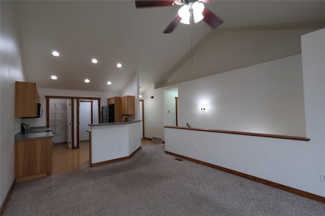 1515 11th St W, Columbia Falls, MT 59912 - unfurnished living room featuring vaulted ceiling, light colored carpet, baseboards, recessed lighting, and a ceiling fan
