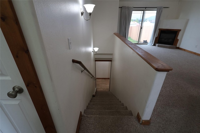 1515 11th St W, Columbia Falls, MT 59912 - staircase featuring carpet flooring, a fireplace, and baseboards