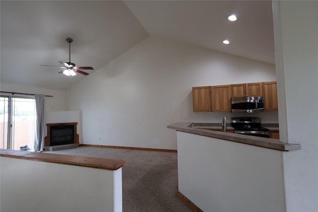 1515 11th St W, Columbia Falls, MT 59912 - kitchen with appliances with stainless steel finishes, a glass covered fireplace, ceiling fan, open floor plan, and high vaulted ceiling