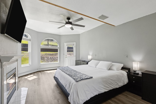 2965 Terrace Dr, Missoula, MT 59803 - bedroom with wood finished floors, a tile fireplace, access to exterior, and a ceiling fan