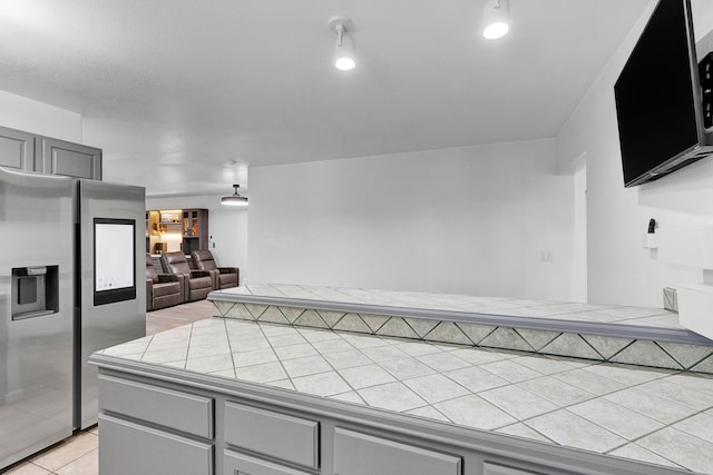 2965 Terrace Dr, Missoula, MT 59803 - kitchen with stainless steel fridge, gray cabinets, tile countertops, and open floor plan