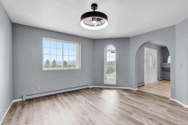 2965 Terrace Dr, Missoula, MT 59803 - spare room with a baseboard heating unit, arched walkways, wood finished floors, and baseboards