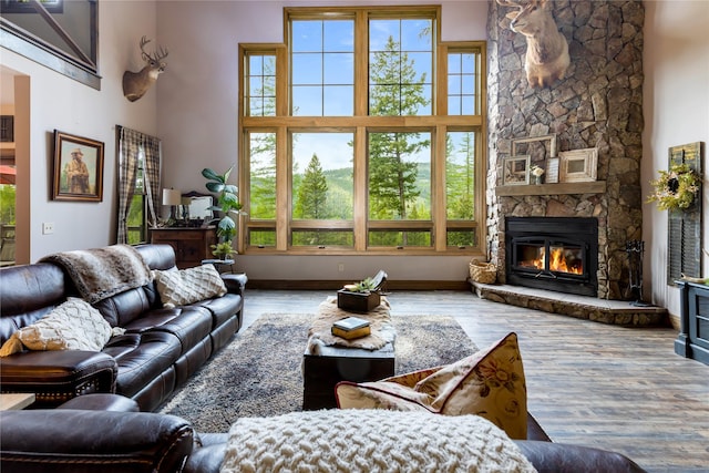 25 Hodge Rdg, Kila, MT 59920 - living room with a towering ceiling, a stone fireplace, wood finished floors, and baseboards