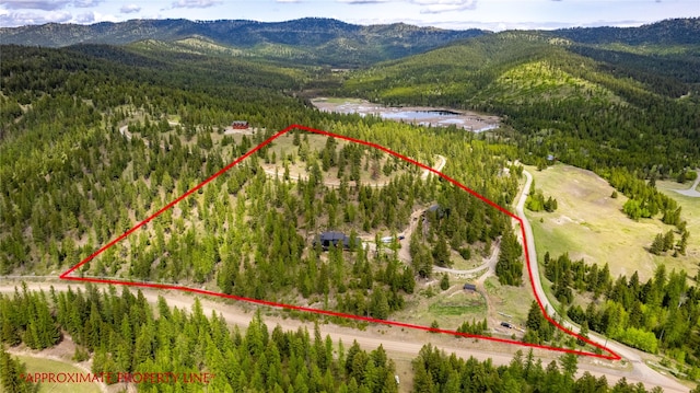 25 Hodge Rdg, Kila, MT 59920 - aerial overview of property's location featuring a heavily wooded area, a mountainous background, and property parcel outlined
